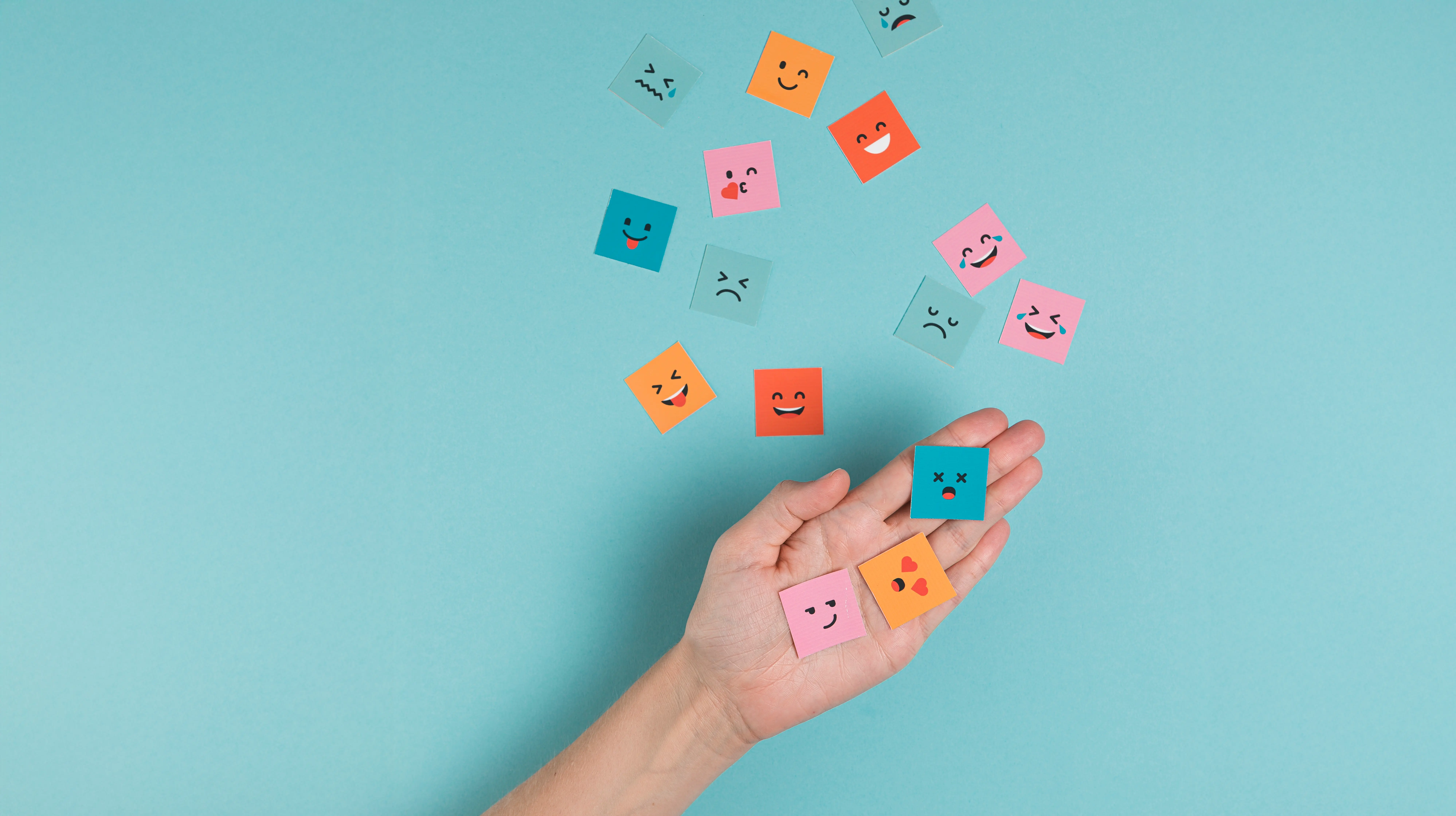 mano-sosteniendo-caras-sonrientes-cuadradas.webp